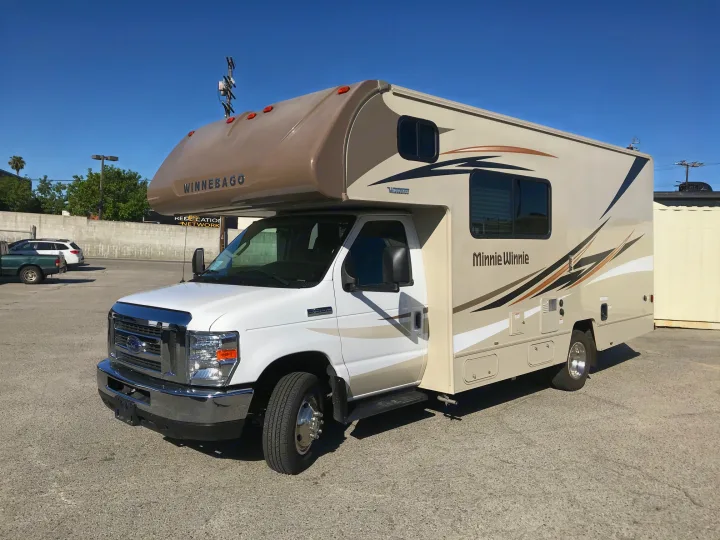 Winnebago Minnie Winnie Class C RV rental parked on a paved lot under a clear sky. Ready for your next adventure!. Winnebago Minnie Winnie 2019
