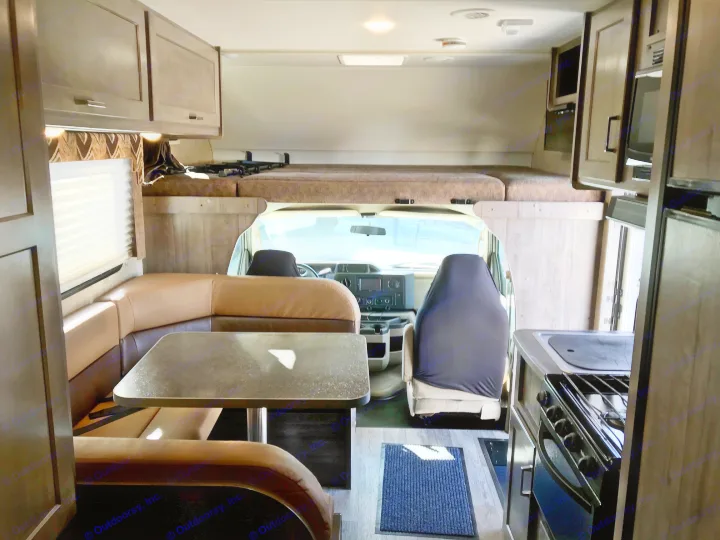 Spacious RV rental interior: A dinette, kitchen, and over-cab bunk are visible, ready for comfortable road trips.. Winnebago Minnie Winnie 2019