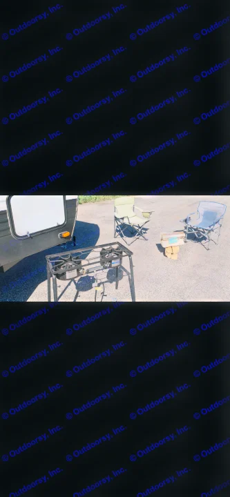 Perfect RV rental setup: two camping chairs, a two-burner outdoor stove, and stacked wood for a relaxed outdoor scene.. Keystone Bunkhouse 2020