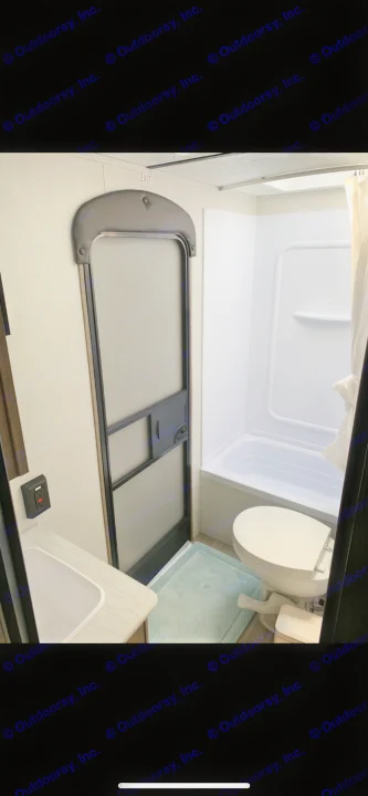 This RV rental bathroom includes a sink, sliding screen door, toilet, and full shower/bathtub.. Keystone Bunkhouse 2020