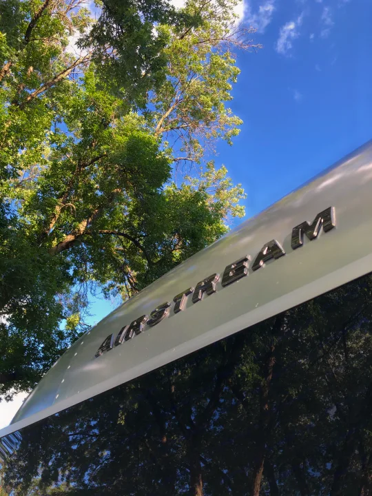The iconic Airstream RV rental is parked among green trees, reflecting nature on its shiny surface. Ready for adventure!. Airstream Bambi 2021