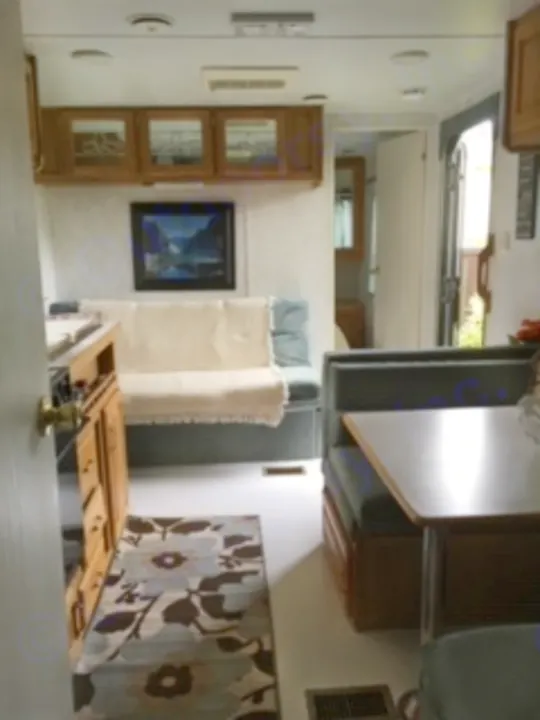 Experience a comfortable RV rental! Interior view shows a living area with a couch, table, and storage cabinets in this travel trailer.. Electra Electra 1996