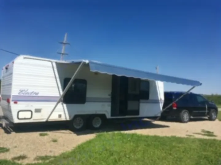 RV rental: This white travel trailer with its awning extended is hitched to an SUV, ready for camping adventures.. Electra Electra 1996