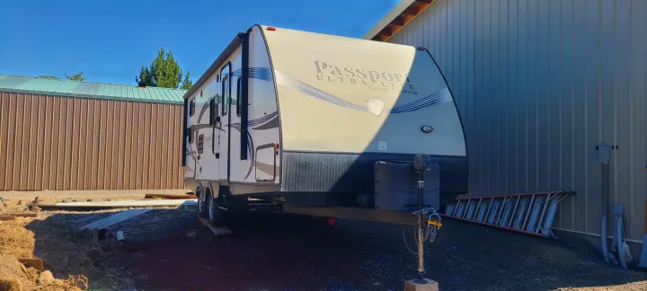 A large, light-colored Passport Ultra Lite travel trailer parked outside, suitable for an RV rental experience.. Keystone Passport 2016