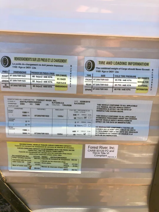 This RV rental's detailed information label displays tire specs, loading capacity, and compliance data for safety.. Forest River Evo 2019