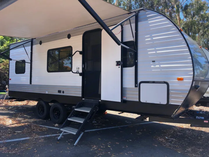 White travel trailer RV rental with awning extended and steps deployed, ready for your adventure.. Forest River Evo 2019