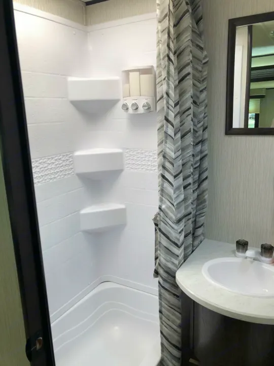 See this modern **rv rental** bathroom. Features a compact shower with built-in shelves & a sink vanity.. Heartland Trail Runner 2020