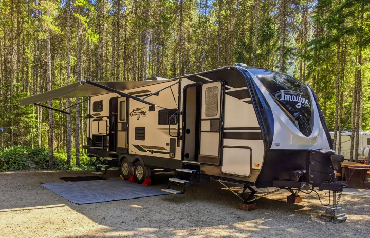 An Imagine RV rental travel trailer is perfectly set up at a shaded forest campground for your outdoor adventure.. Grand Design Imagine 2019
