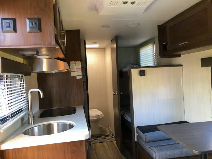 RV rental interior: A bright, modern camper with kitchen, bathroom, bunk beds, and dinette setup. Ready for your adventure!. Forest River Cherokee Wolf Pup 2019