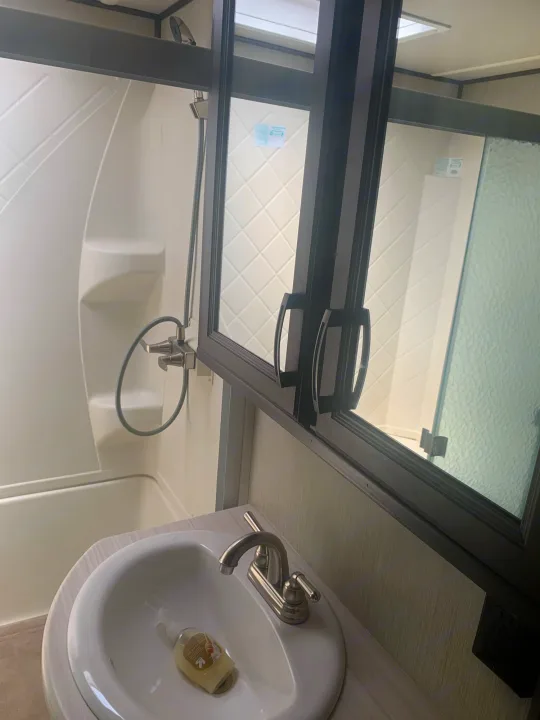 Clean RV rental bathroom featuring a sink, tub/shower combo, and mirrored cabinet. Perfect for your next trip!. Palomino Columbus 2018