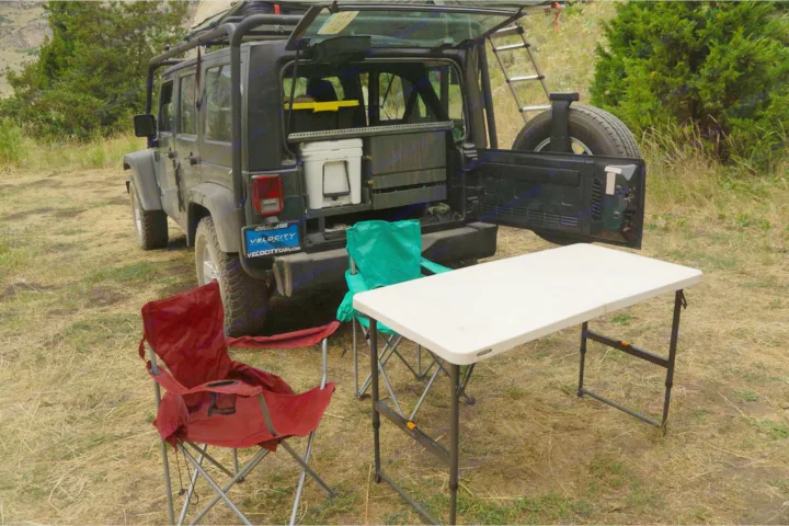 Ready for adventure: This RV rental Jeep shows a well-organized overland camping setup with chairs and a table.. Jeep Wrangler Unlimited 2018
