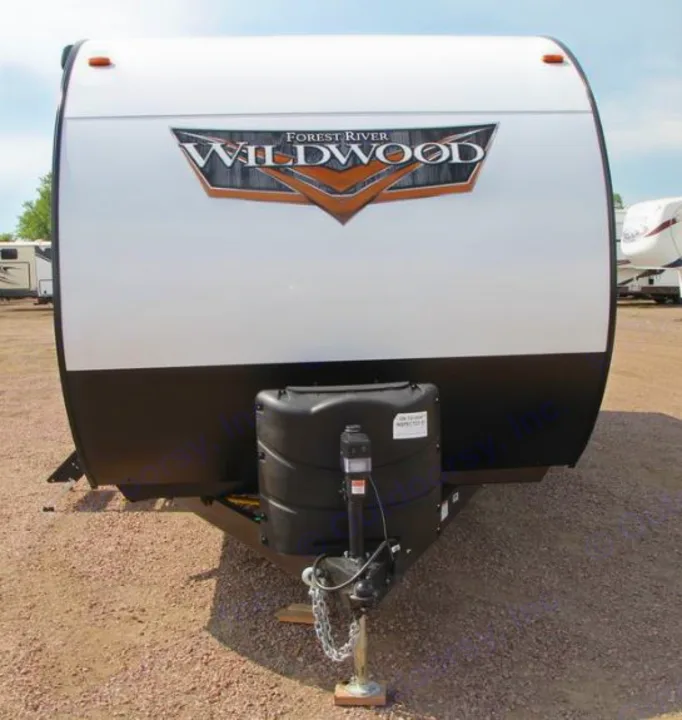 Front view of a white and black Forest River Wildwood rv rental travel trailer, showing hitch & propane tanks.. Forest River Wildwood 2021