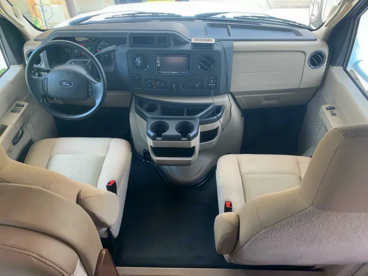 Step inside this RV rental! View of the front cabin with steering wheel, dashboard, control panel, and comfortable seats.. Thor Chateau 2019