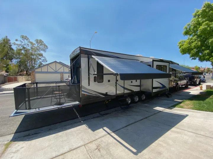 Spacious toy hauler RV rental with awnings extended & rear patio setup, ready for adventure on a sunny day.. Forest River Xlr Thunrderbolt 2020