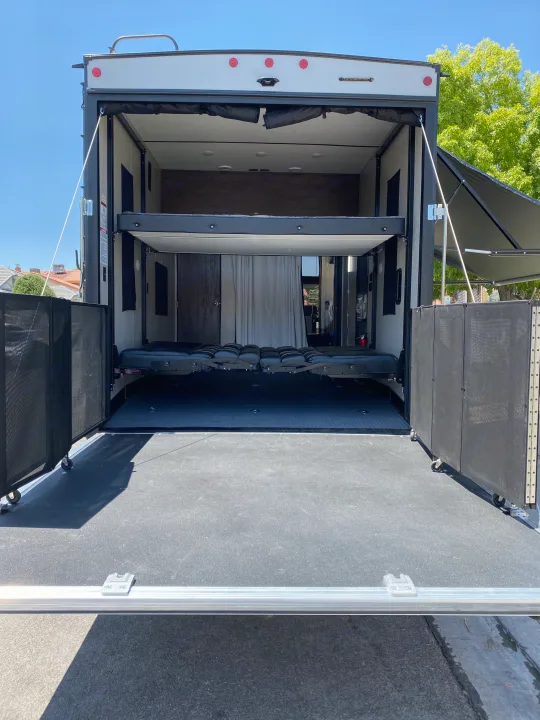 RV rental: Rear view of a toy hauler showing the spacious ramp patio, screen enclosure, and interior bunk beds.. Forest River Xlr Thunrderbolt 2020