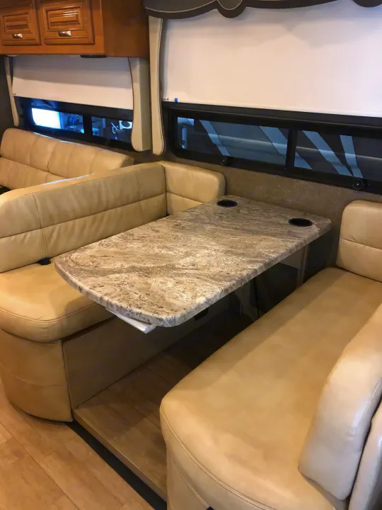Experience our comfortable RV rental dining area: plush U-shaped booth, granite-look table with cup holders.. Thor Motor Coach Challenger 2018