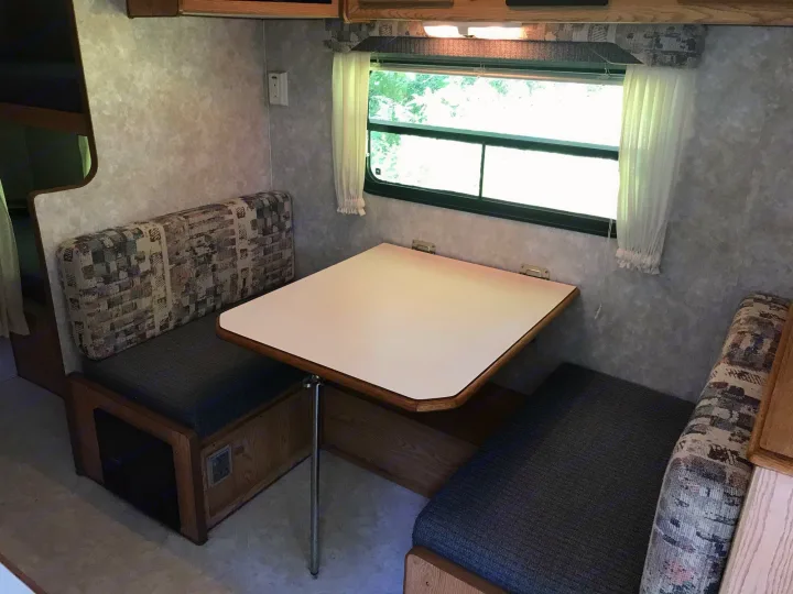 Cozy RV rental dinette with cushioned bench seating, a removable table, and bright window for your travels.. Sunline Solaris/Delivery&Set-up 2002