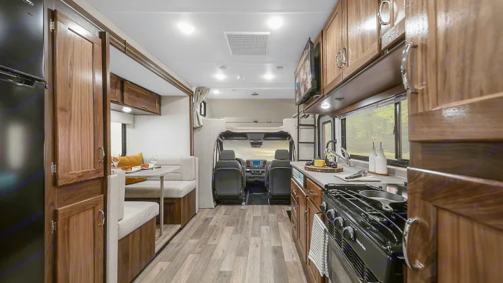 Spacious RV rental interior with a modern kitchen, cozy dining area, and driver's cab, ready for your road trip adventures.. Winnebago Vita 2020