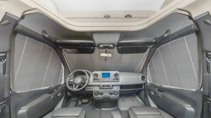 RV rental cockpit: Front interior with a Mercedes-Benz dashboard, fully covered windows by dark gray shades for privacy.. Winnebago Vita 2020