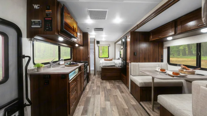A spacious RV rental interior with a fully equipped kitchen, dinette, and rear sleeping area.. Winnebago Vita 2020
