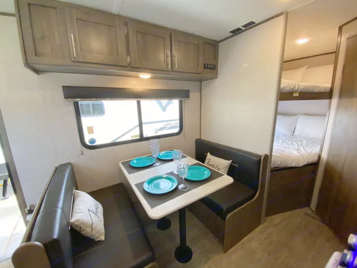Explore this rv rental: a comfy dining booth, overhead cabinets, and bunk beds offer a home-like feel on the road.. Dutchmen Aspen Trail 2021