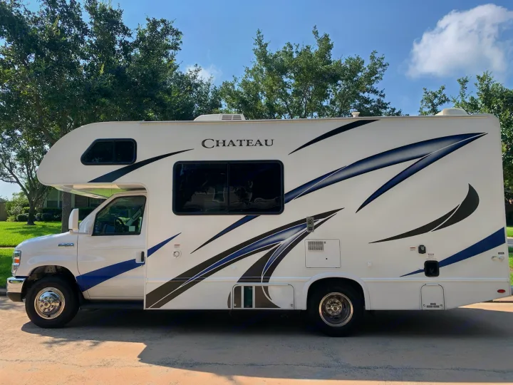 White Chateau RV rental, a Class C motorhome with striking black and blue graphics, parked on a sunny day.. Thor Chateau 2019