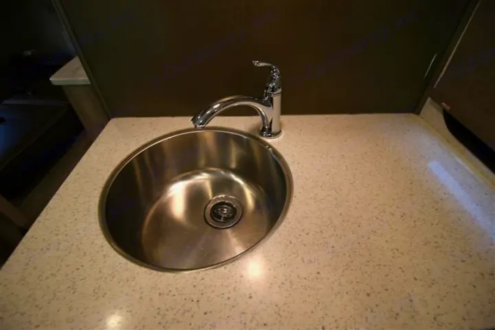 Modern RV rental interior featuring a stainless steel sink, chrome faucet, and speckled countertop.. Forest River Forester 2020
