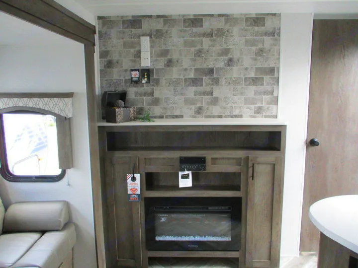 Modern RV rental living area featuring a decorative brick fireplace, entertainment unit, and plush seating.. Forest River Evo 2021