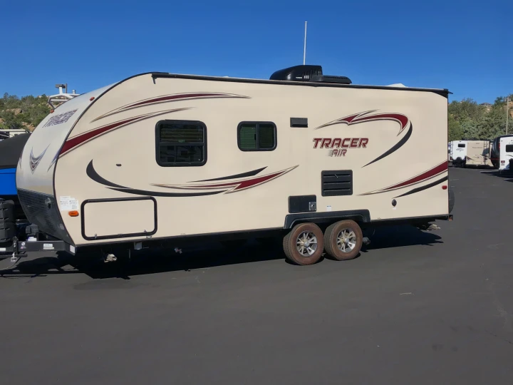 A clean, beige Tracer Air travel trailer, perfect for your next RV rental, parked in a sunny lot.. Prime Time Tracer 2017