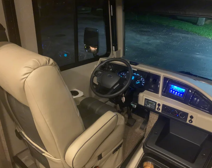 Experience an RV rental from the driver's perspective! Night shot of the spacious motorhome cockpit & dashboard.. Holiday Rambler Admiral 2021