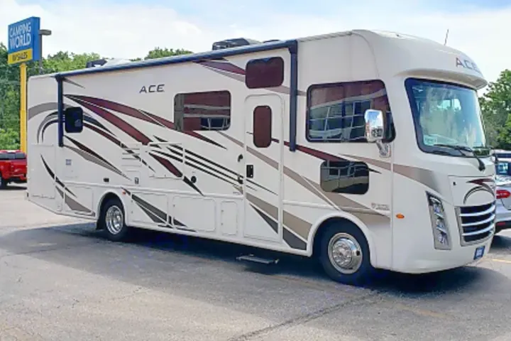White Class A motorhome, possibly an RV rental, with brown and grey graphics, parked at Camping World RV Sales.. Thor Motor Coach 30.3 2019