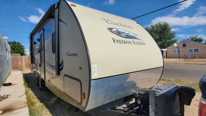 Light tan Coachmen Freedom Express travel trailer, ideal for an rv rental, parked outdoors on a sunny day.. Coachmen Freedom Express 2015