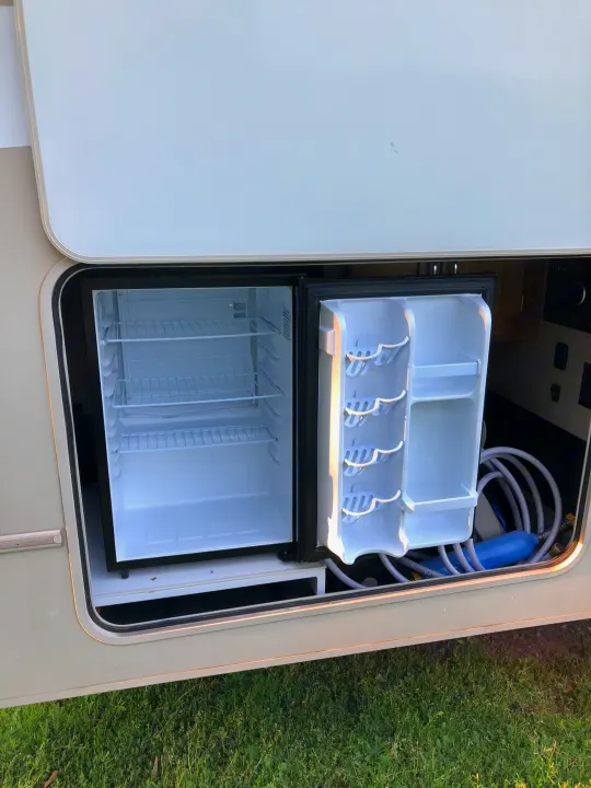 RV rental: Open side compartment with empty mini-fridge, water filter, and hose for easy access.. Winnebago Minnie Winnie 2017