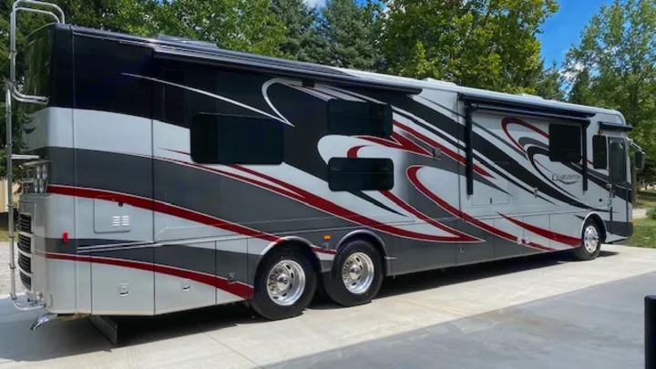 This large, black, white, gray, and red luxury RV rental is parked on pavement, perfect for a comfortable road trip.. Charleston Charleston Motorhome 2015