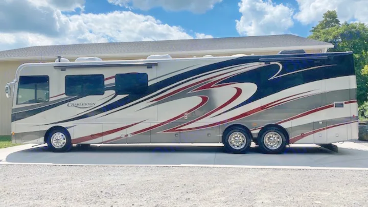 This luxury Charleston RV rental motorhome is shown parked outdoors under a partly cloudy sky.. Charleston Charleston Motorhome 2015