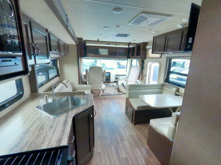 RV rental interior featuring a modern kitchen with sink & stove, dining area, and front cabin. Ready for your next adventure.. Thor Motor Coach A.C.E 2020