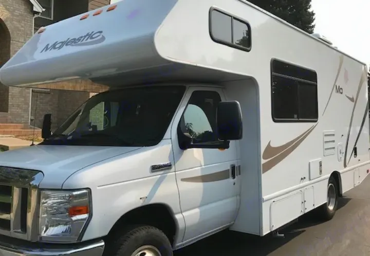 Front-side view of a white Majestic Class C RV, a great choice for RV rental and travel.. Thor Motor Coach Four Winds Majestic 2014