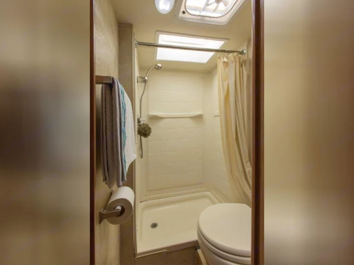This RV rental features a compact bathroom with a shower, toilet, and essential amenities for your comfort on the go.. Thor Motor Coach Four Winds Majestic 2014
