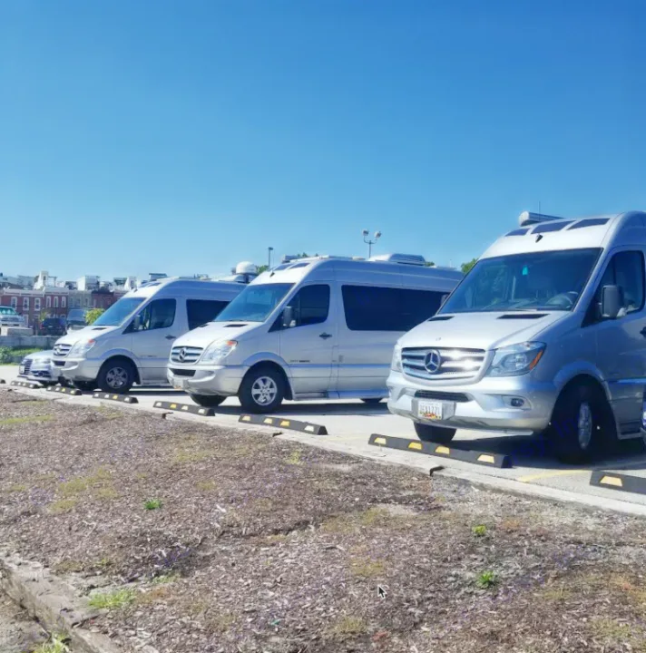 A row of silver Mercedes-Benz Sprinter vans, converted for rv rental, parked outdoors on a sunny day.. Roadtrek Ssagile 2014