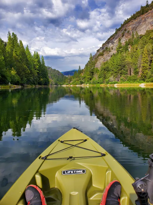 Kayaking on a serene lake, surrounded by tree-covered mountains. Perfect outdoor adventure after an RV rental journey.. Carson Trailer Toy Hauler 2007