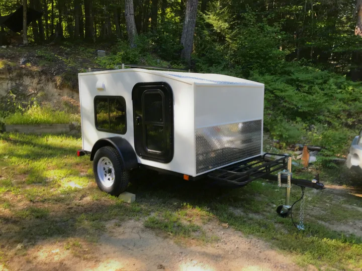 Experience nature with this white compact travel trailer. Perfect for an RV rental, it features a side door, window, and front rack.. Other Other 2020