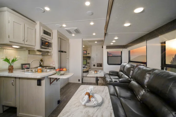 Explore this modern RV rental interior: a bright kitchen, cozy recliners, and stunning mountain views from panoramic windows.. Coachmen Chaparral 2018