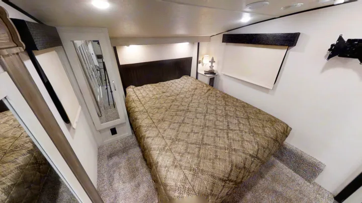 RV rental bedroom: a large bed, mirrored closet, and wall-mounted TV bracket in a cozy motorhome interior.. Coachmen Chaparral 2018