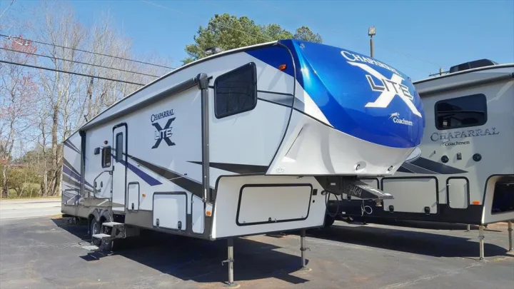 Explore! White & blue Chaparral Lite fifth-wheel RV, with black accents, ready for your next adventure. Perfect rv rental or purchase.. Coachmen Chaparral 2018