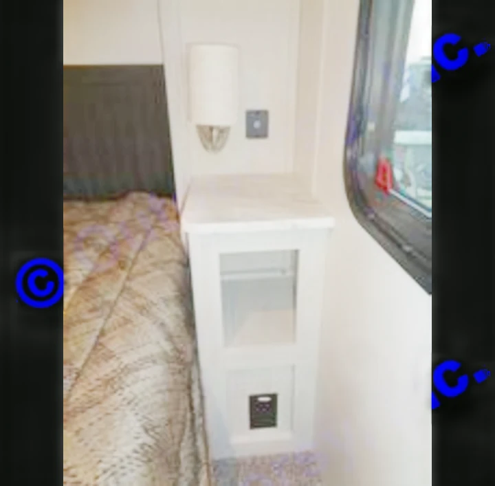 Explore an RV rental's functional bedside area, featuring a narrow nightstand with storage, wall-mounted lighting, and convenient charging ports.. Coachmen Chaparral 2018