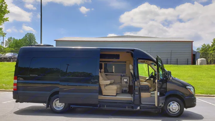 Black luxury custom Sprinter van for rv rental, side door open displaying plush tan interior.. Mercedes-Benz Sprinter 2015