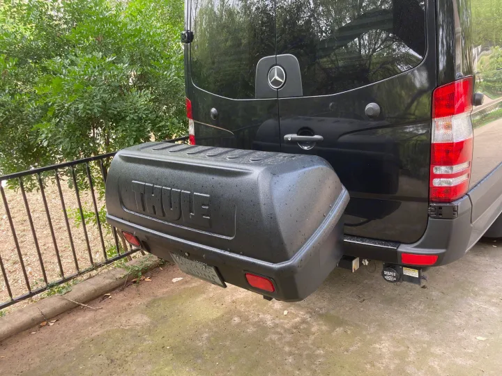Rear of a black Mercedes-Benz Sprinter RV rental, with a Thule cargo box for extra gear.. Mercedes-Benz Sprinter 2015
