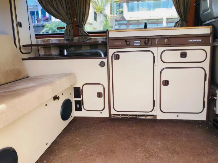 Westfalia RV rental interior: beige/brown, with comfortable bench & compact kitchenette for travel.. Volkswagen Westfalia 1982