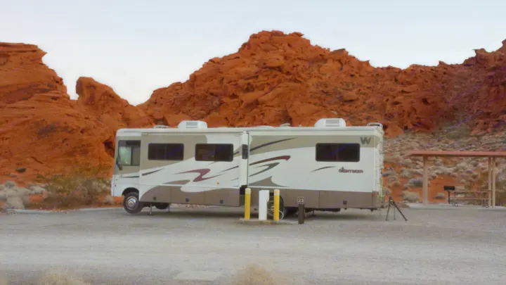 An RV rental parked at a desert campsite, surrounded by stunning red rock formations. Perfect for a scenic outdoor adventure.. Winnebago Sightseer 2007