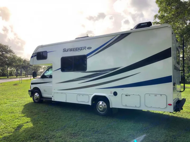 This spacious white Sunseeker Class C motorhome, perfect for an **rv rental** adventure, is parked on green grass.. Forest River sunseeker LE 2350 2020